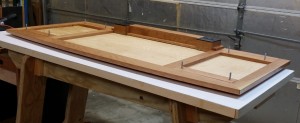 The underside of the desk top, showing braces and carriage bolts.